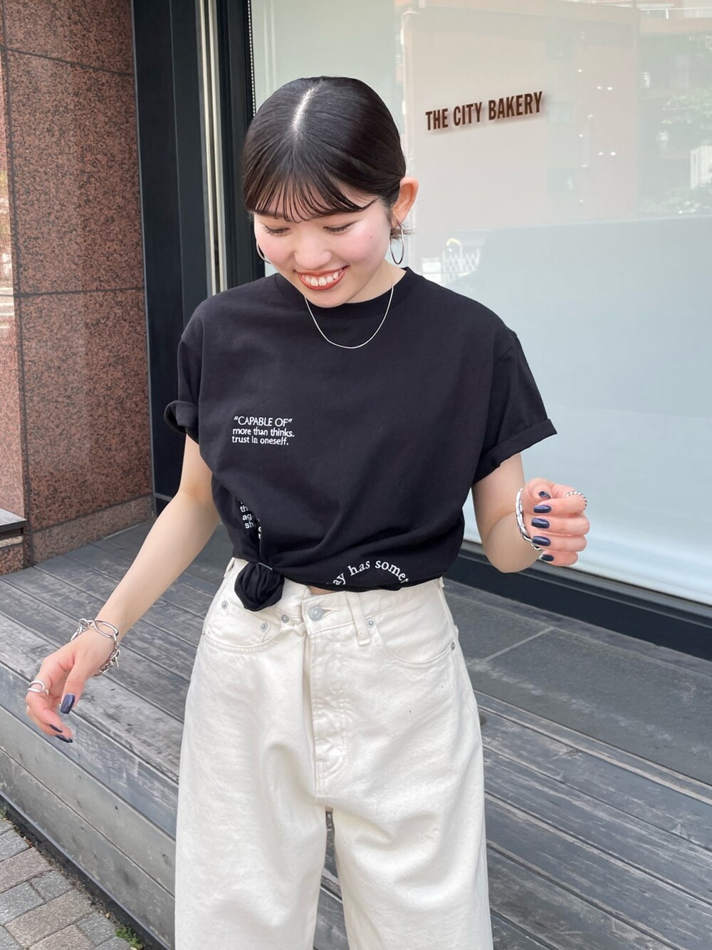 シルバー系のサンダル、ホワイト系のデニムパンツ、ブラック系のTシャツ/カットソーを着用したレディースの夏コーディネートの2枚目の写真