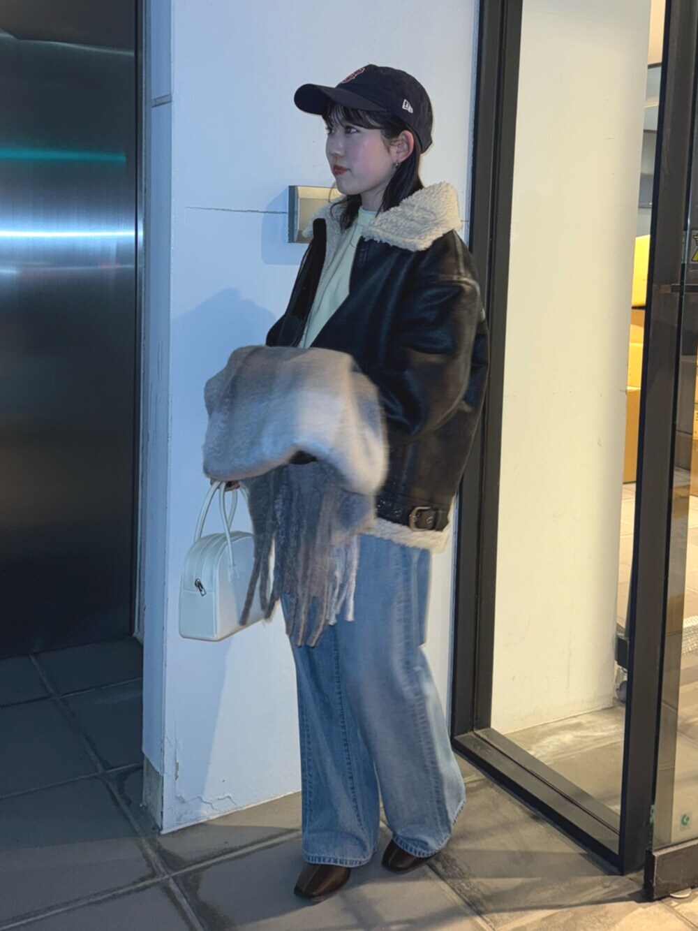 ブラウン系のブーツ、ブルー系のデニムパンツ、イエロー系のニット/セーターを着用したレディースの冬コーディネートの3枚目の写真