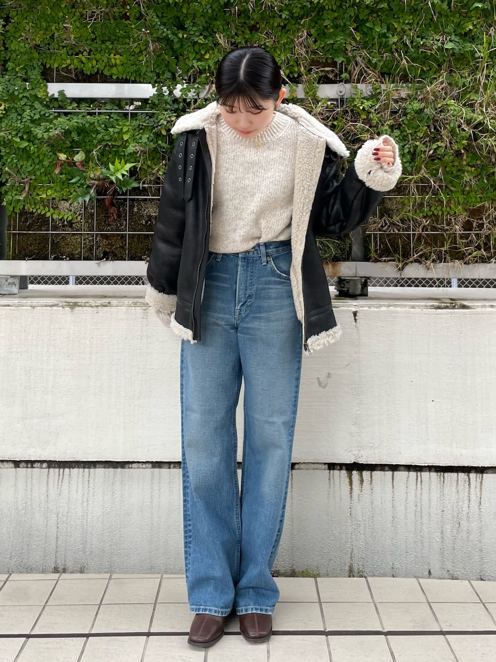 ブルー系のデニムパンツ、ブラウン系のブーツ、ホワイト系のニット/セーターを着用したレディースの秋コーディネートの5枚目の写真