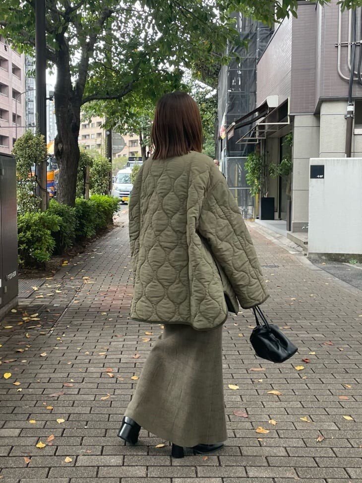 ブラック系のブーツ、グリーン系のブルゾン、レッド系のニット/セーターを着用したレディースの秋コーディネートの4枚目の写真