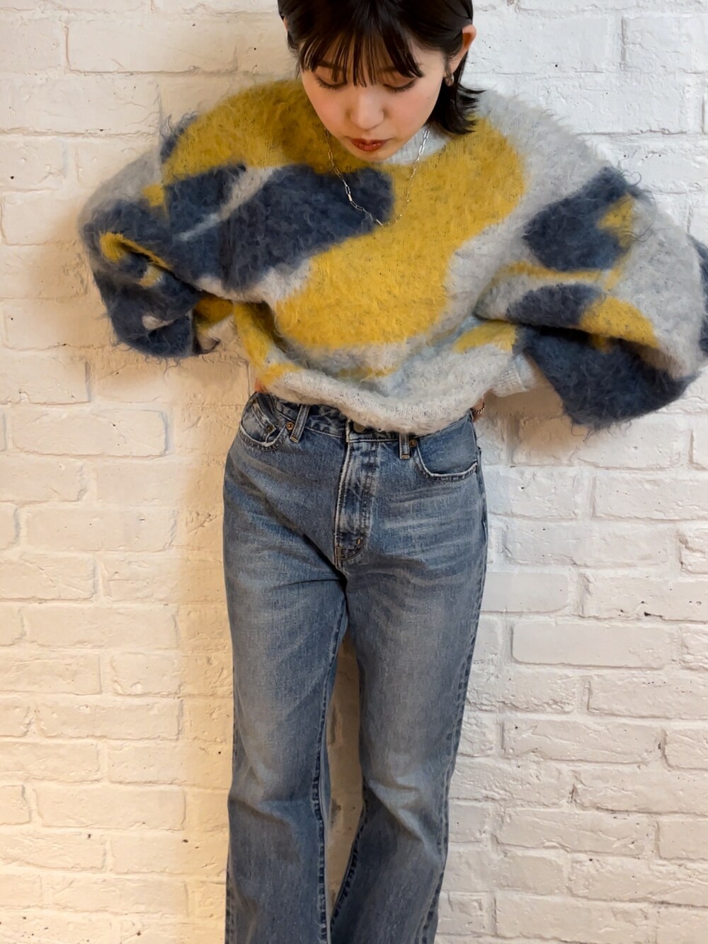 ブルー系のデニムパンツ、ブラック系のブーツ、ブルー系のニット/セーターを着用したレディースの夏コーディネートの6枚目の写真