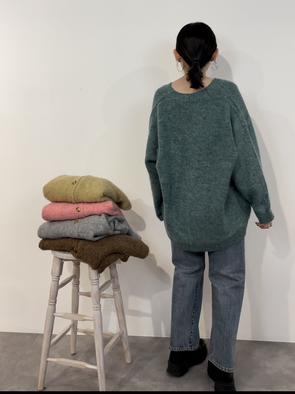 ブルー系のデニムパンツ、ブラック系のブーツ、グリーン系のカーディガン/ボレロを着用したレディースの冬コーディネートの4枚目の写真