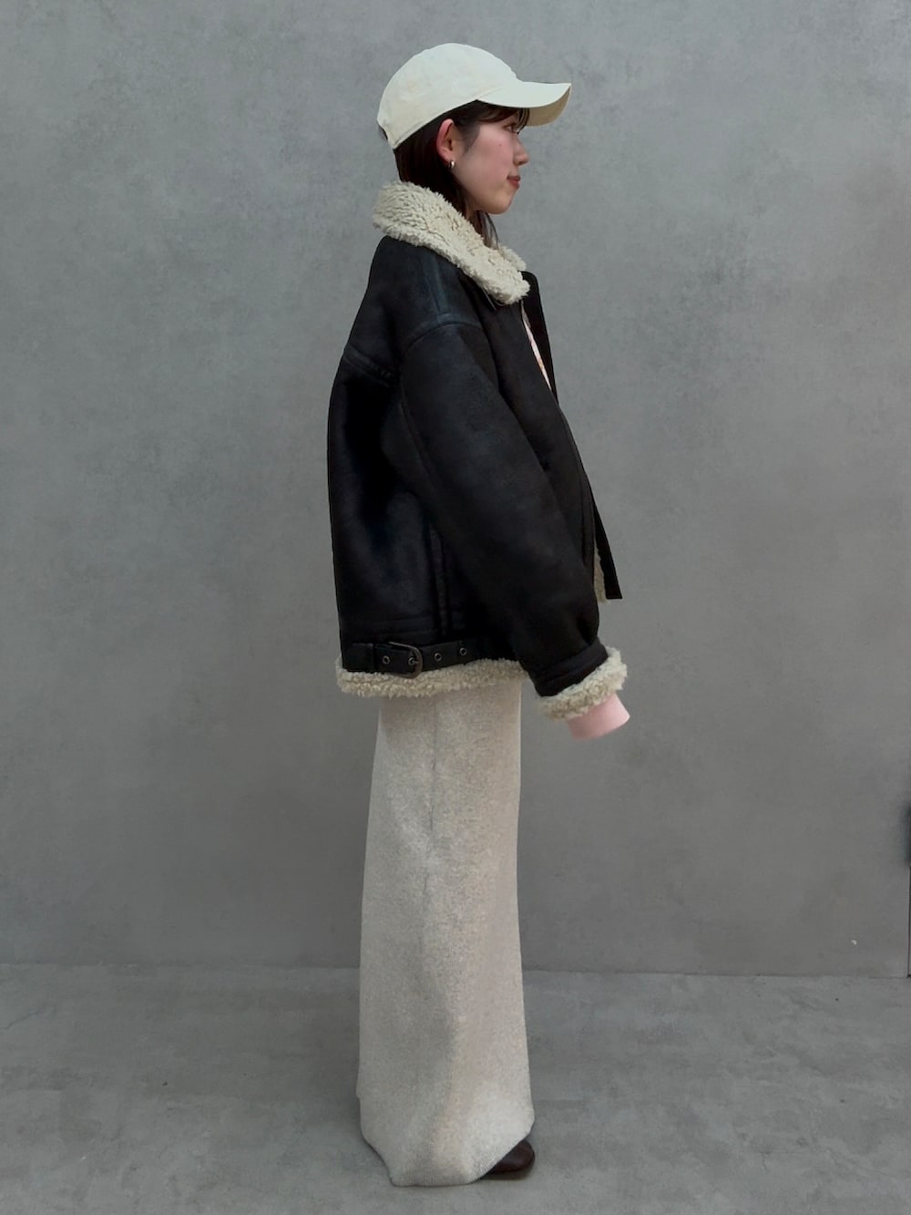 ピンク系のスウェット、グレー系のスカート、ブラウン系のブーツを着用したレディースの冬コーディネートの3枚目の写真