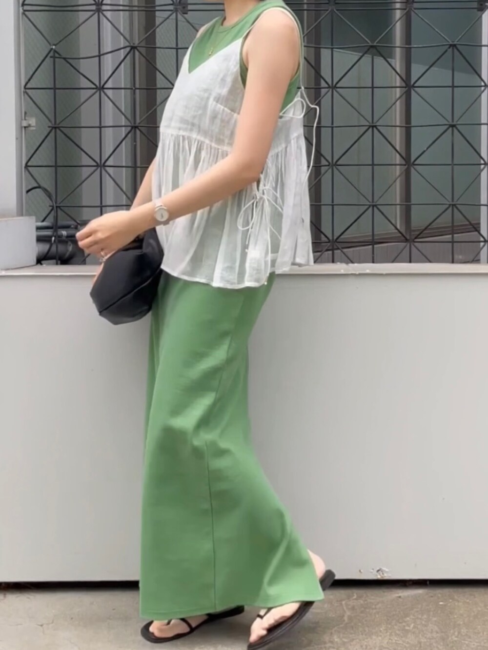 ブラック系のサンダル、ホワイト系のシャツ/ブラウス、グリーン系のワンピースを着用したレディースの春コーディネートの2枚目の写真