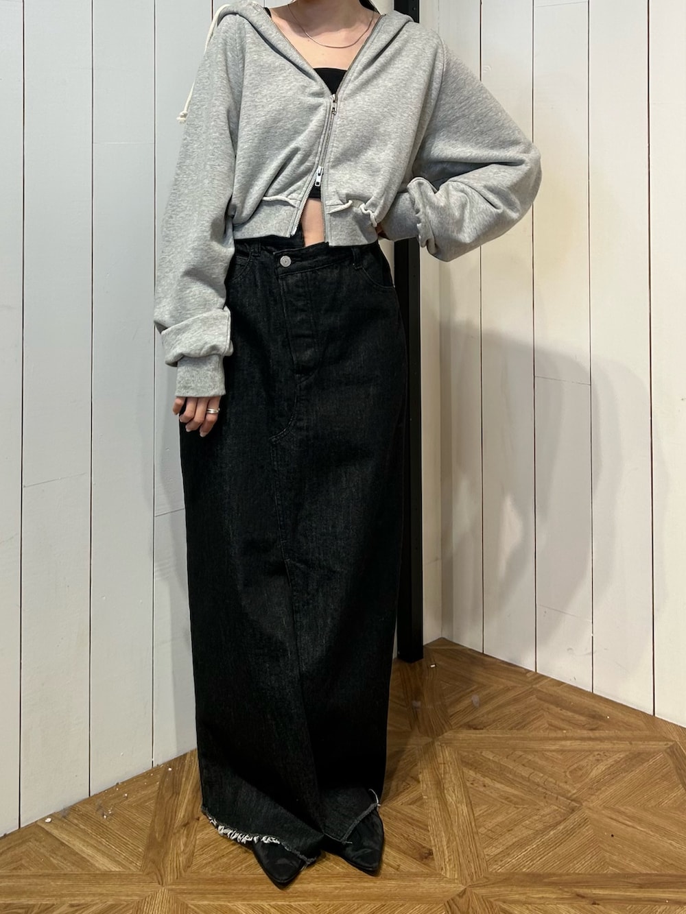 ブラック系のパンプス、ブラック系のスカート、グレー系のパーカーを着用したレディースの春コーディネートの2枚目の写真