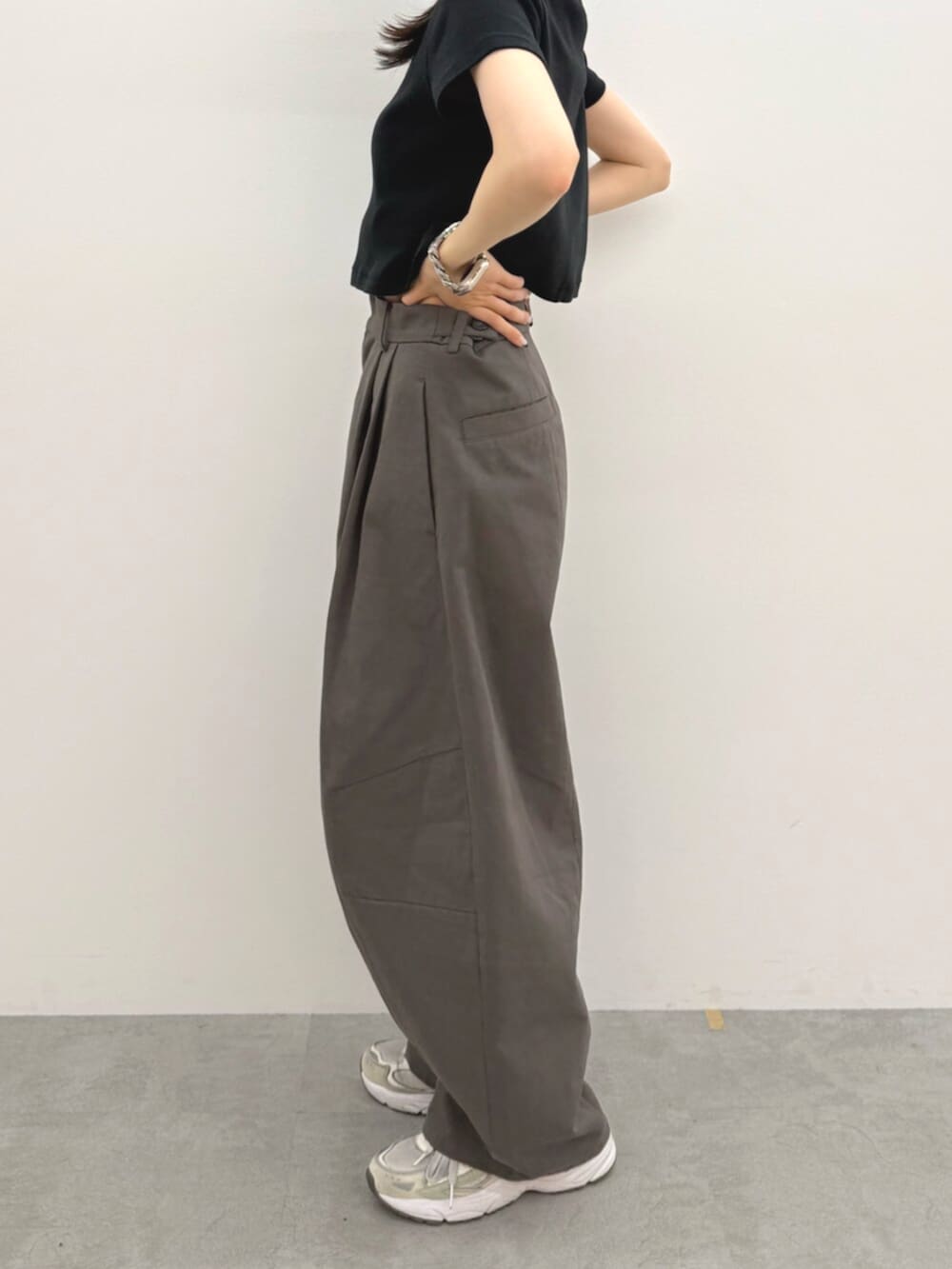 ブラック系のTシャツ/カットソー、グレー系のチノパンツ、ホワイト系のキャップを着用したレディースの春コーディネートの6枚目の写真