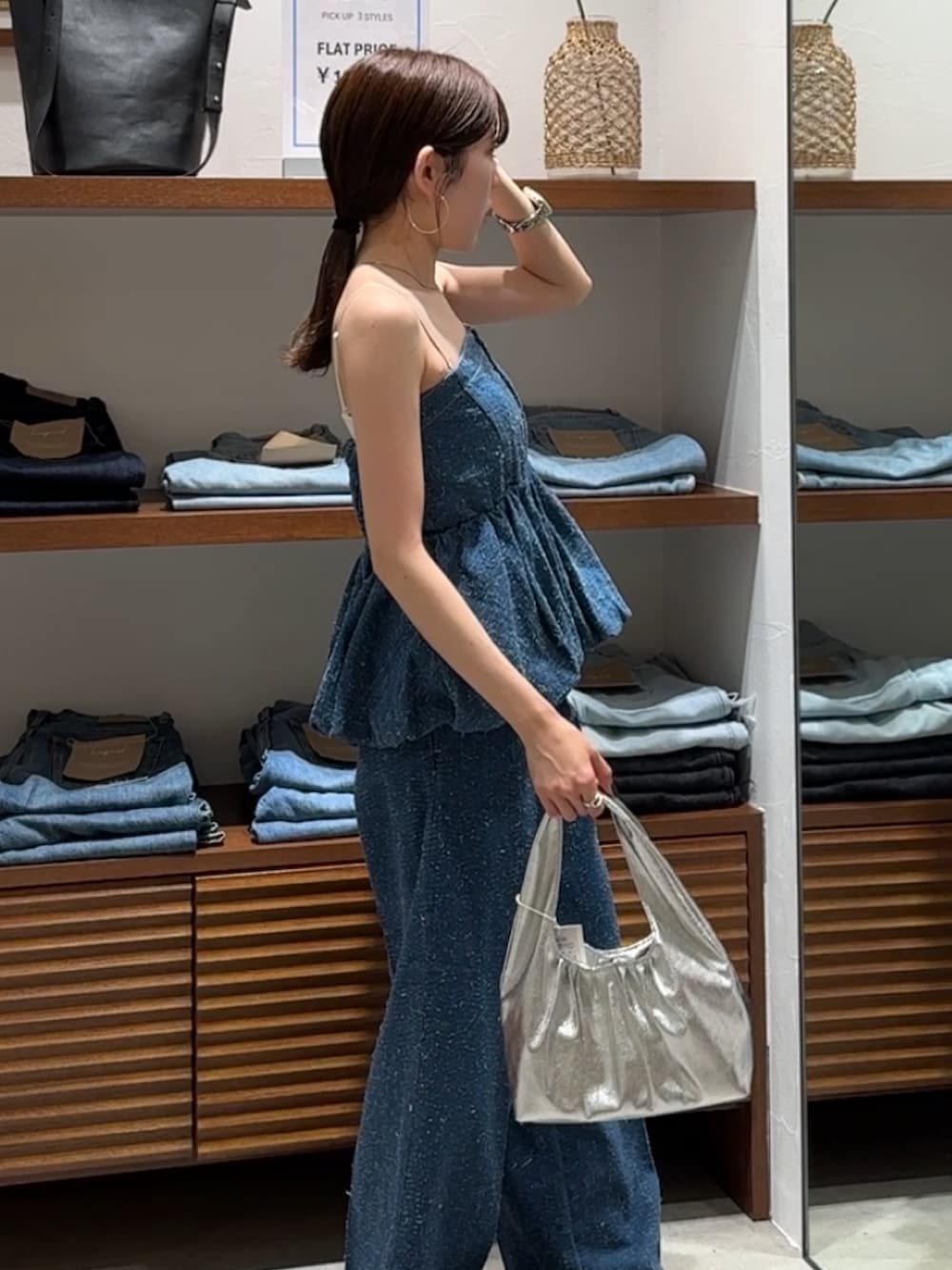 ブルー系のチューブトップ、ブルー系のデニムパンツ、その他のサンダルを着用したレディースの春コーディネートの6枚目の写真
