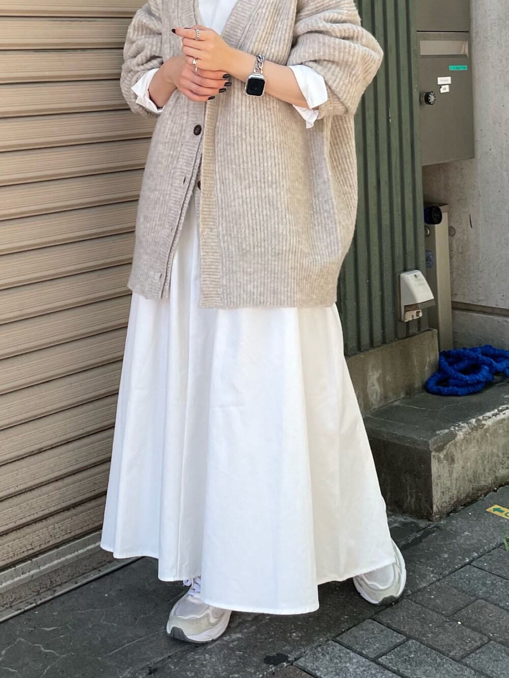 ホワイト系のカーディガン/ボレロ、ブラック系のワンピース、ブラック系のキャップを着用したレディースの秋コーディネートの6枚目の写真