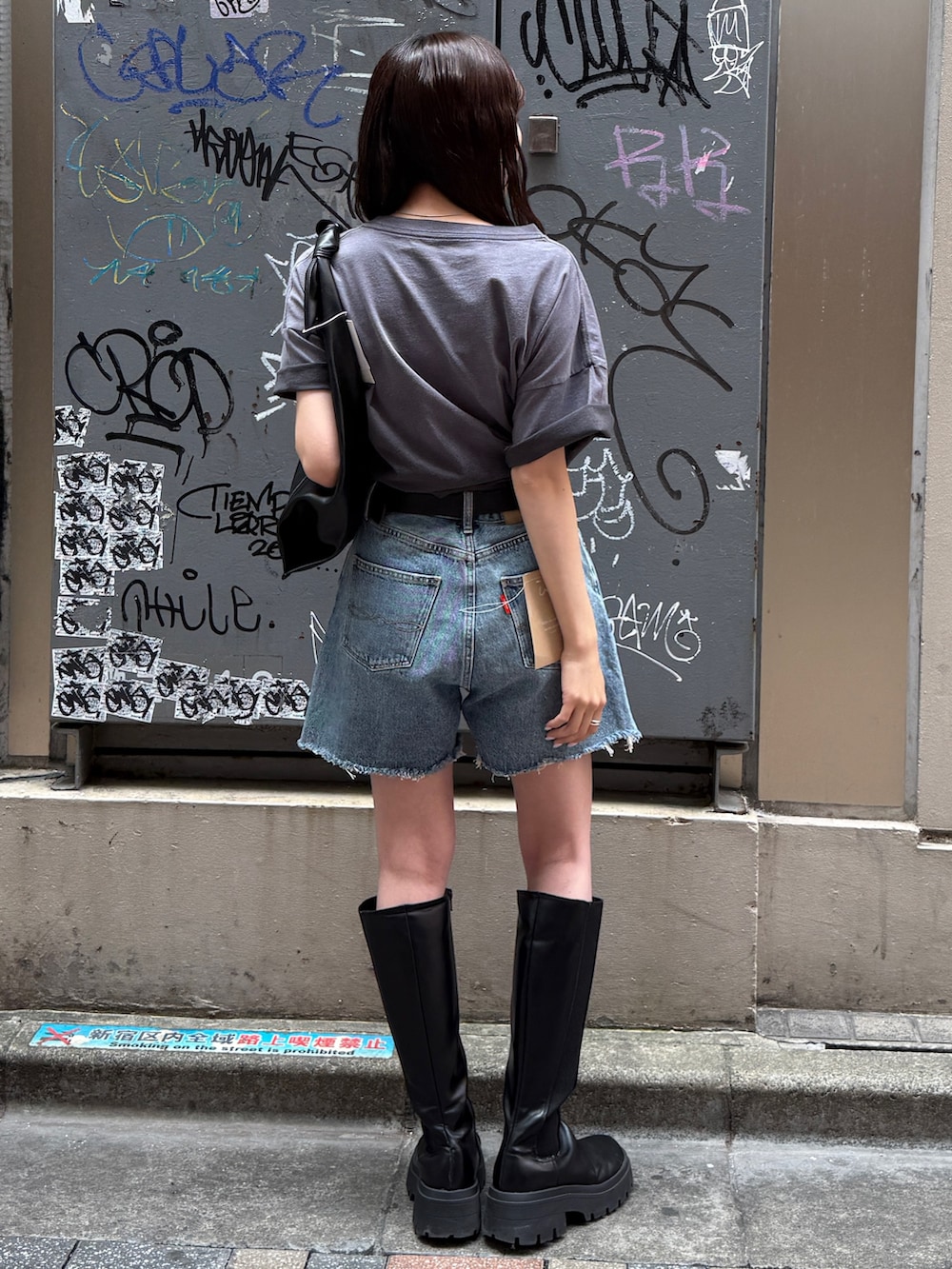 ブルー系のデニムパンツ、グレー系のTシャツ/カットソー、ブラック系のハンドバッグを着用したレディースの春コーディネートの5枚目の写真
