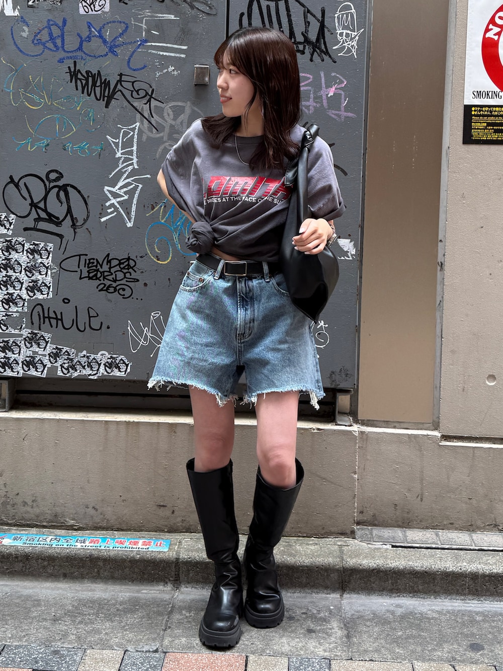 ブルー系のデニムパンツ、グレー系のTシャツ/カットソー、ブラック系のハンドバッグを着用したレディースの春コーディネートの6枚目の写真