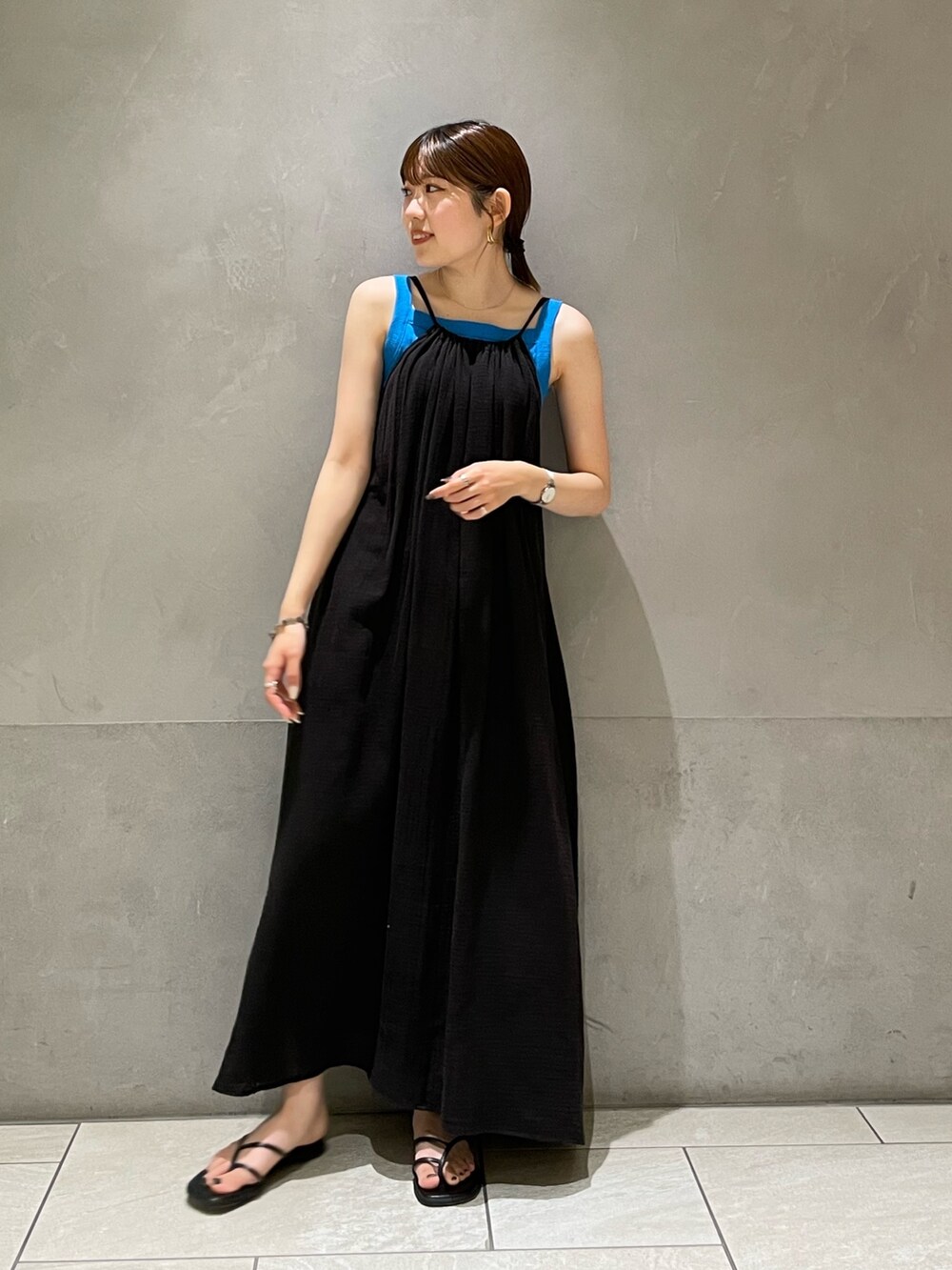 ブルー系のタンクトップ、ブラック系のワンピース、ブラック系のサンダルを着用したレディースの夏コーディネートの5枚目の写真