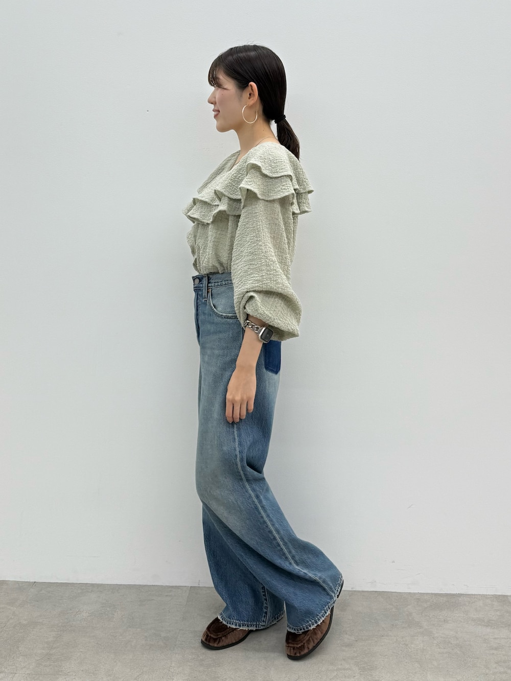 ブルー系のデニムパンツ、ブラウン系のローファー、ブルー系のシャツ/ブラウスを着用したレディースの秋コーディネートの3枚目の写真