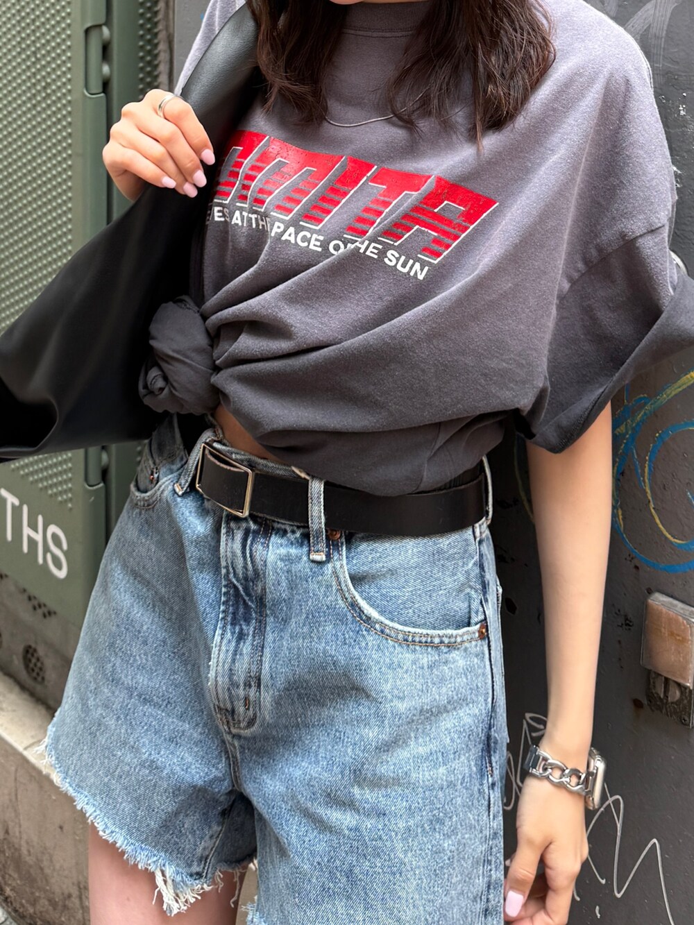 ブルー系のデニムパンツ、グレー系のTシャツ/カットソー、ブラック系のハンドバッグを着用したレディースの春コーディネートの3枚目の写真