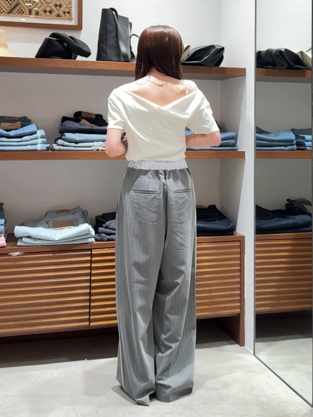グレー系のその他パンツ、ブラック系のサンダル、ホワイト系のTシャツ/カットソーを着用したレディースの春コーディネートの6枚目の写真