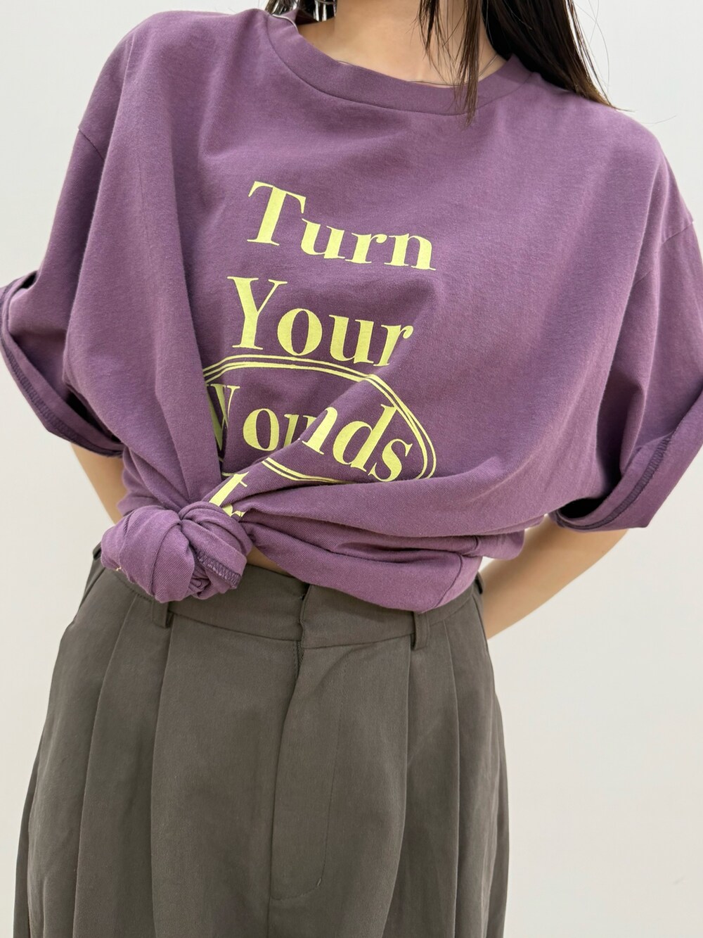 グレー系のチノパンツ、パープル系のTシャツ/カットソーを着用したレディースの春コーディネートの7枚目の写真