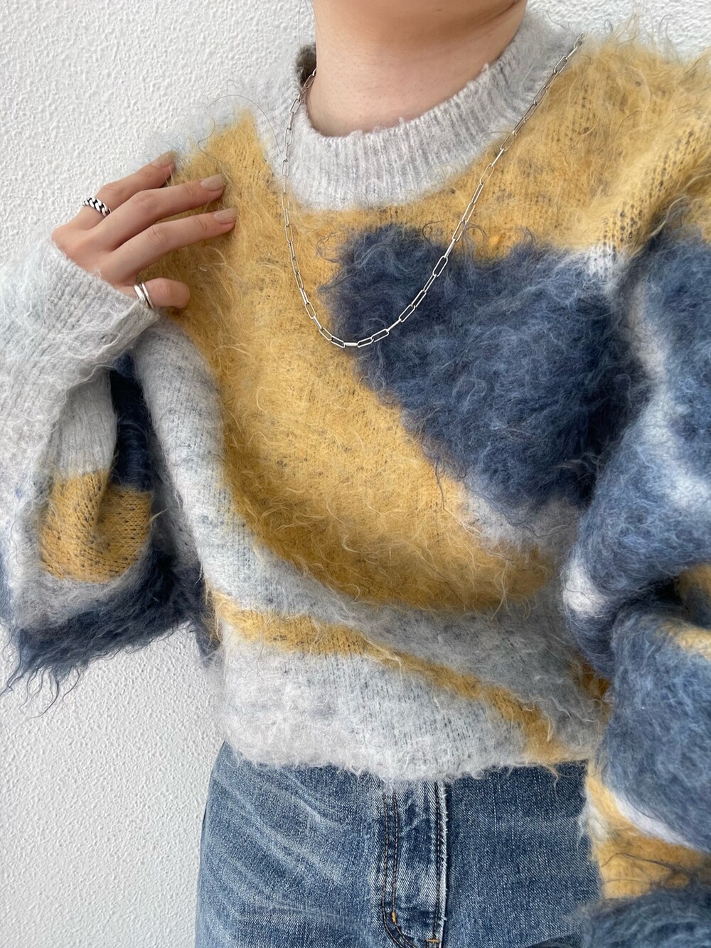 ブルー系のデニムパンツ、ブラック系のブーツ、ブルー系のニット/セーターを着用したレディースの夏コーディネートの5枚目の写真