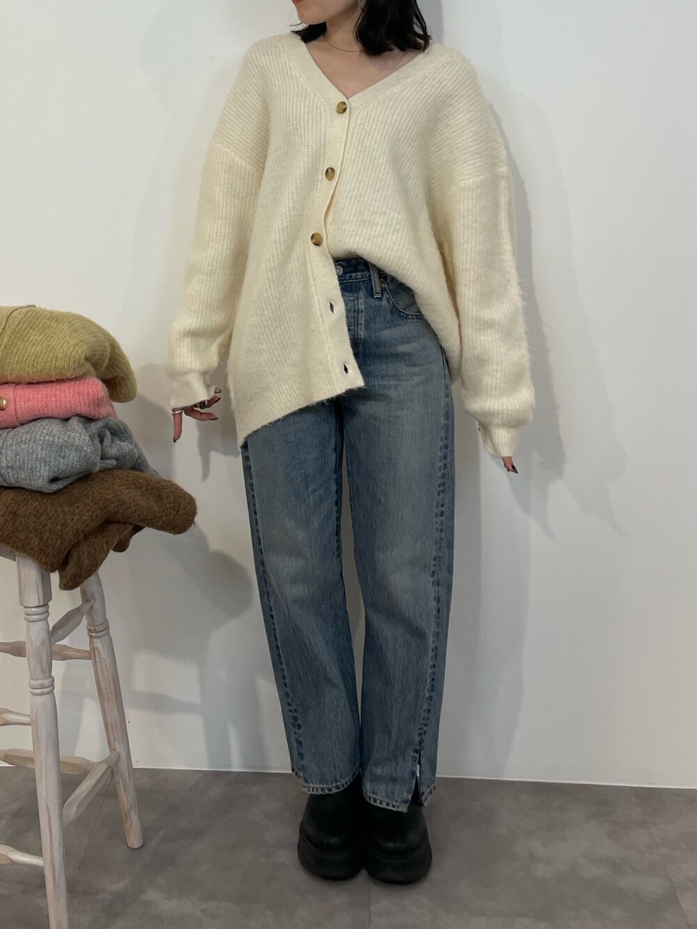 ブルー系のデニムパンツ、ブラック系のブーツ、ホワイト系のカーディガン/ボレロを着用したレディースの冬コーディネートの3枚目の写真