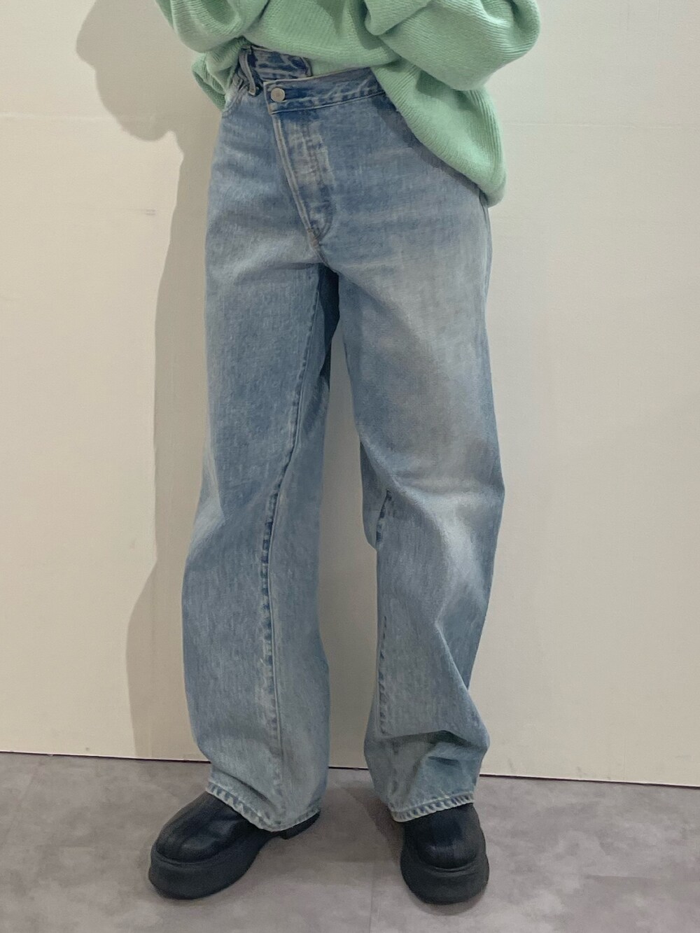 ブルー系のデニムパンツ、ブラック系のブーツ、ホワイト系のTシャツ/カットソーを着用したレディースの冬コーディネートの7枚目の写真