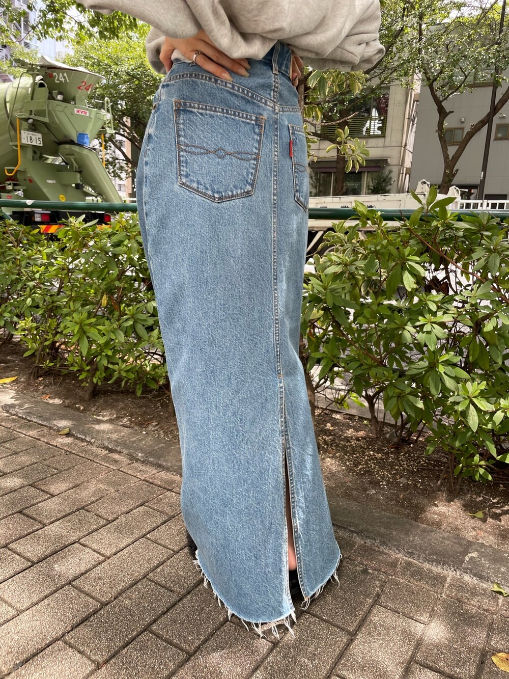 ブルー系のデニムスカート、グレー系のスウェット、ブラック系のサンダルを着用したレディースの夏コーディネートの6枚目の写真