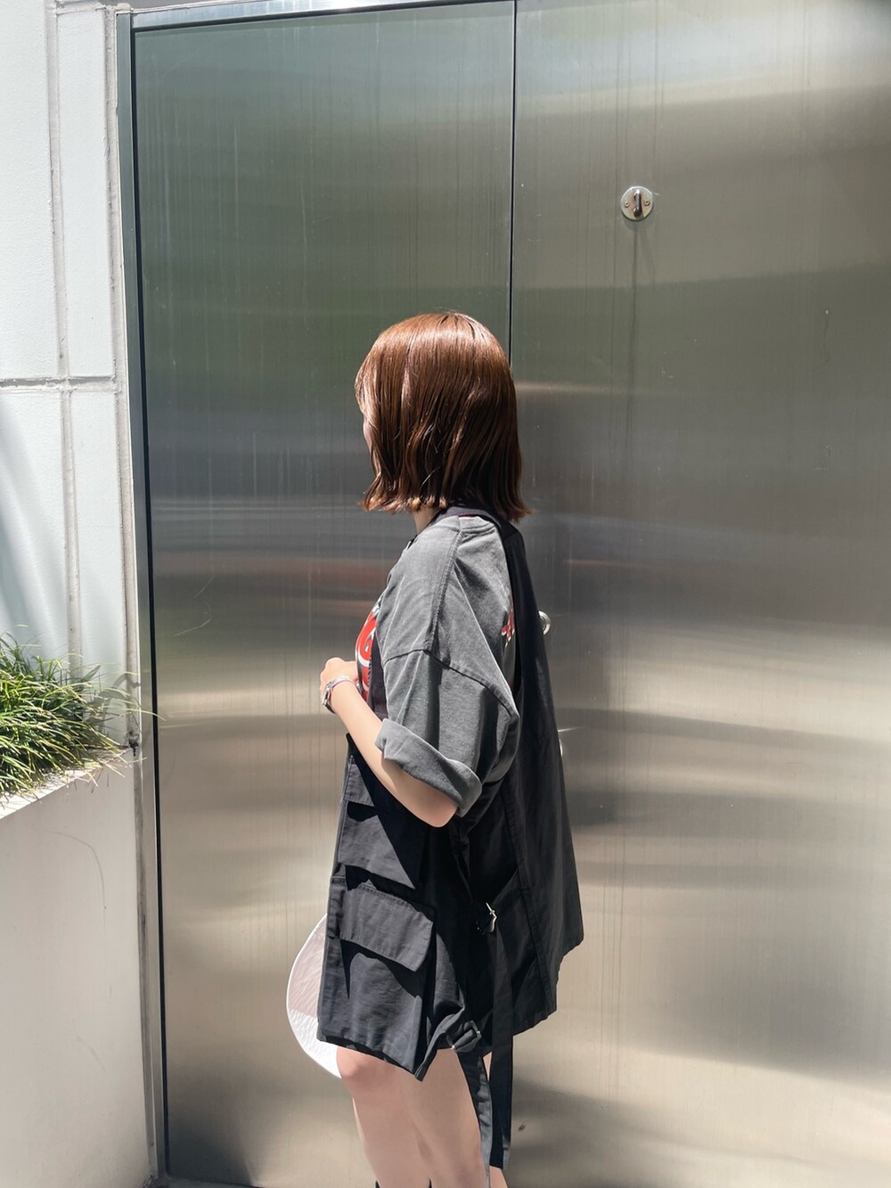 グレー系のTシャツ/カットソー、ブラック系のベスト、ホワイト系のハットを着用したレディースの春コーディネートの5枚目の写真