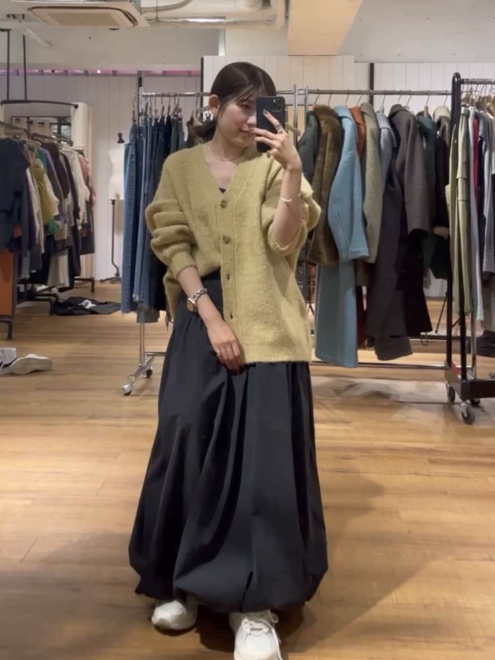 ブラック系のスカート、イエロー系のカーディガン/ボレロを着用したレディースの秋コーディネートの3枚目の写真