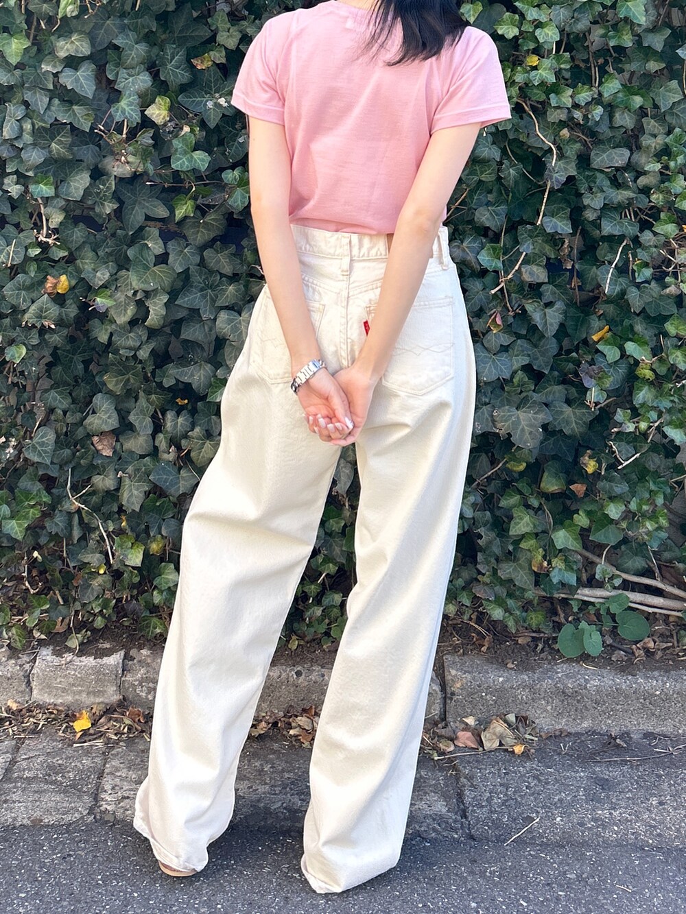 ピンク系のTシャツ/カットソー、ホワイト系のデニムパンツ、ホワイト系のサンダルを着用したレディースの春コーディネートの9枚目の写真