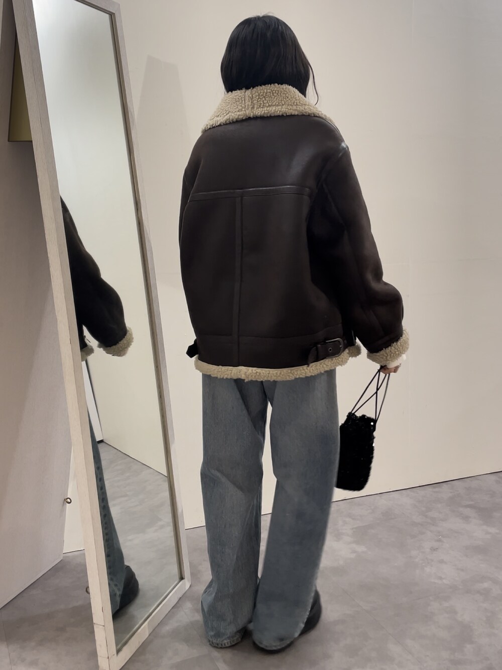 ブルー系のデニムパンツ、ブラック系のブーツ、ピンク系のニット/セーターを着用したレディースの冬コーディネートの4枚目の写真