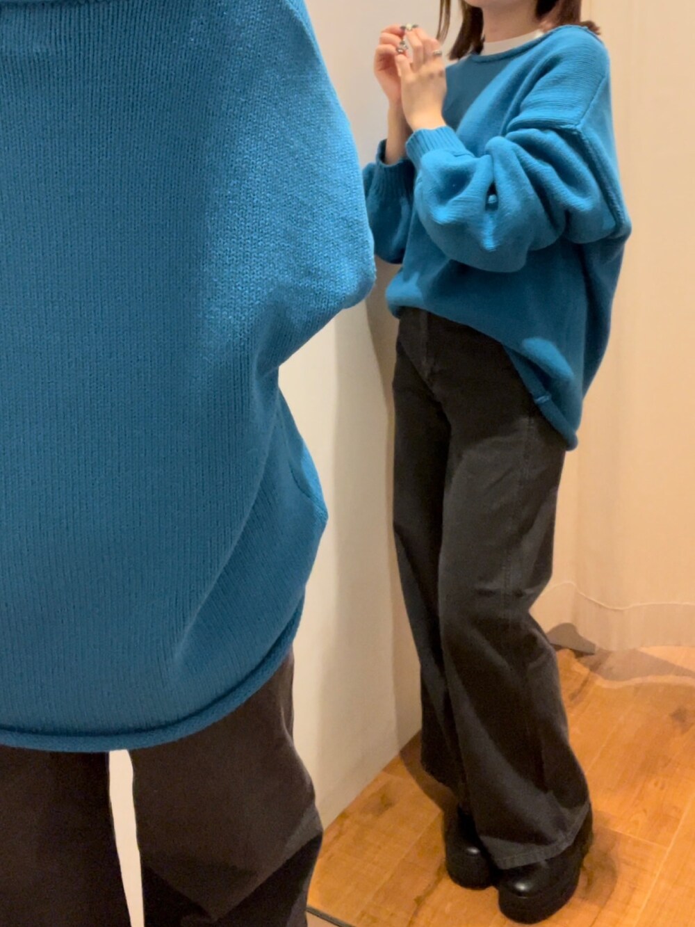 ブラック系のデニムパンツ、ブルー系のニット/セーター、ホワイト系のTシャツ/カットソーを着用したレディースの秋コーディネートの6枚目の写真