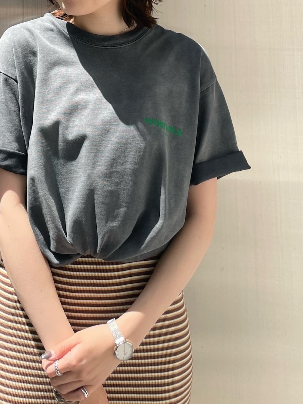 ブラウン系のワンピース、ゴールド系のパンプス、グレー系のTシャツ/カットソーを着用したレディースの夏コーディネートの5枚目の写真