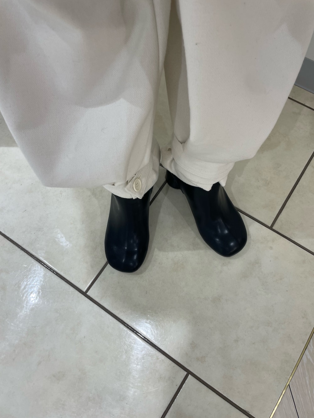 ブラック系のブーツ、ホワイト系のカーゴパンツ、グリーン系のニット/セーターを着用したレディースの冬コーディネートの5枚目の写真