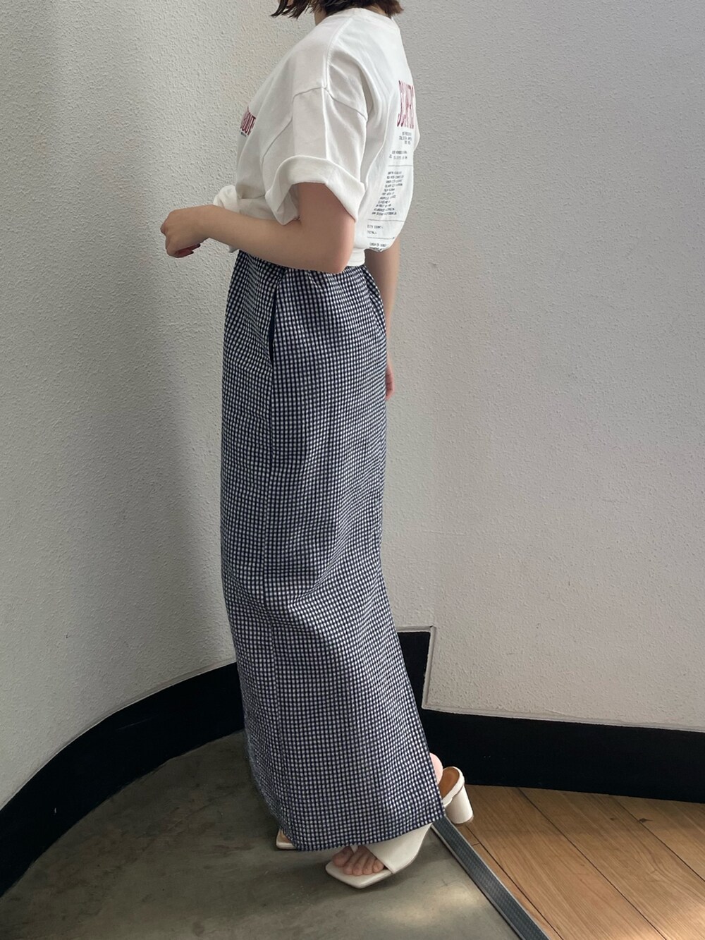 ブルー系のワンピース、ホワイト系のTシャツ/カットソー、ホワイト系のサンダルを着用したレディースの春コーディネートの6枚目の写真