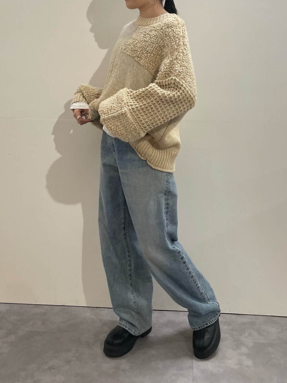 ホワイト系のTシャツ/カットソー、ブルー系のデニムパンツ、ブラック系のブーツを着用したレディースの冬コーディネートの6枚目の写真