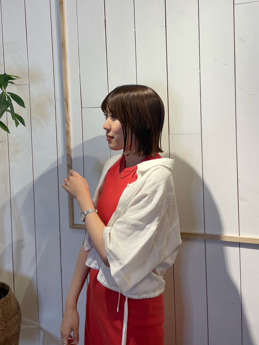オレンジ系のワンピース、ホワイト系のシャツ/ブラウスを着用したレディースの春コーディネートの5枚目の写真