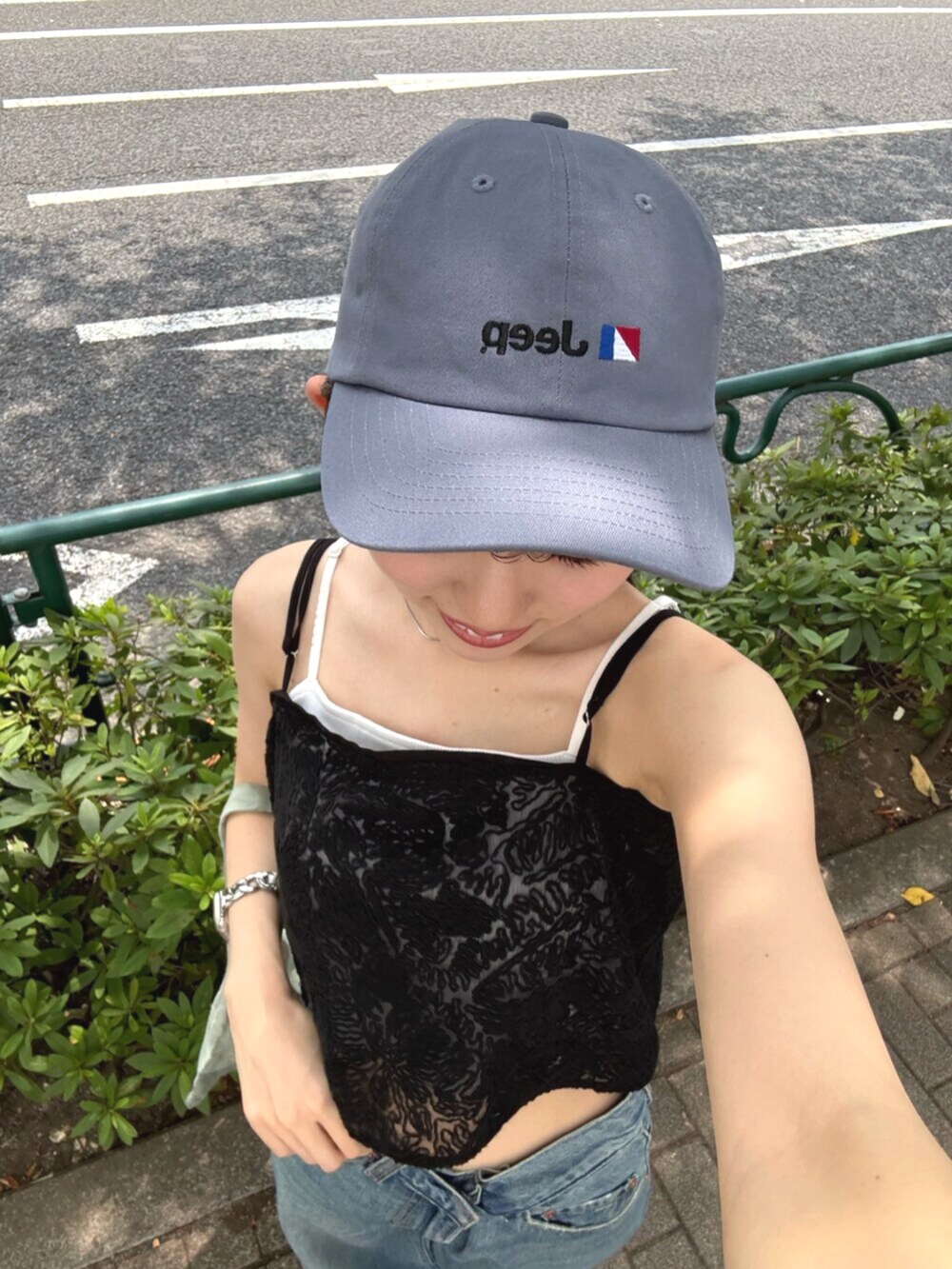 ブラック系のサンダル、グリーン系のトートバッグ、ブルー系のデニムパンツを着用したレディースの夏コーディネートの8枚目の写真