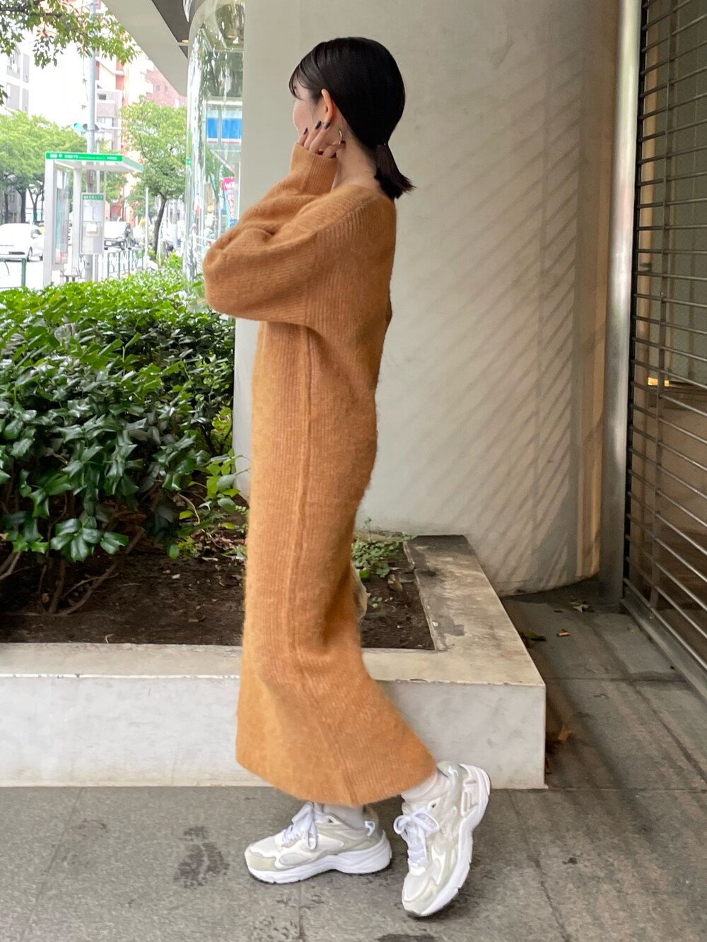 ホワイト系のハンドバッグ、オレンジ系のワンピースを着用したレディースの秋コーディネートの4枚目の写真