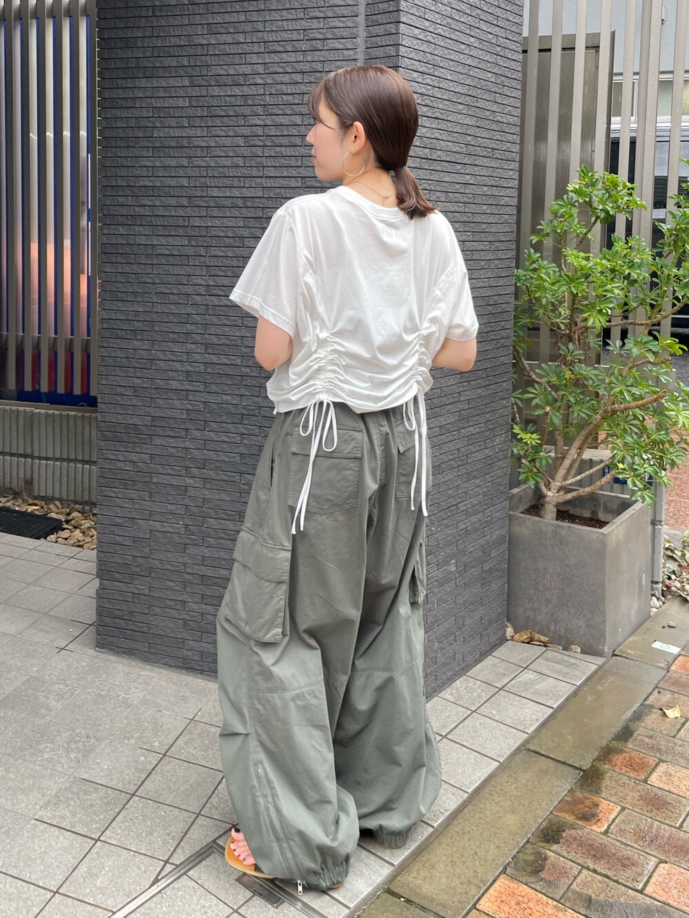 ホワイト系のTシャツ/カットソー、ブラック系のサンダル、グリーン系のカーゴパンツを着用したレディースの夏コーディネートの3枚目の写真