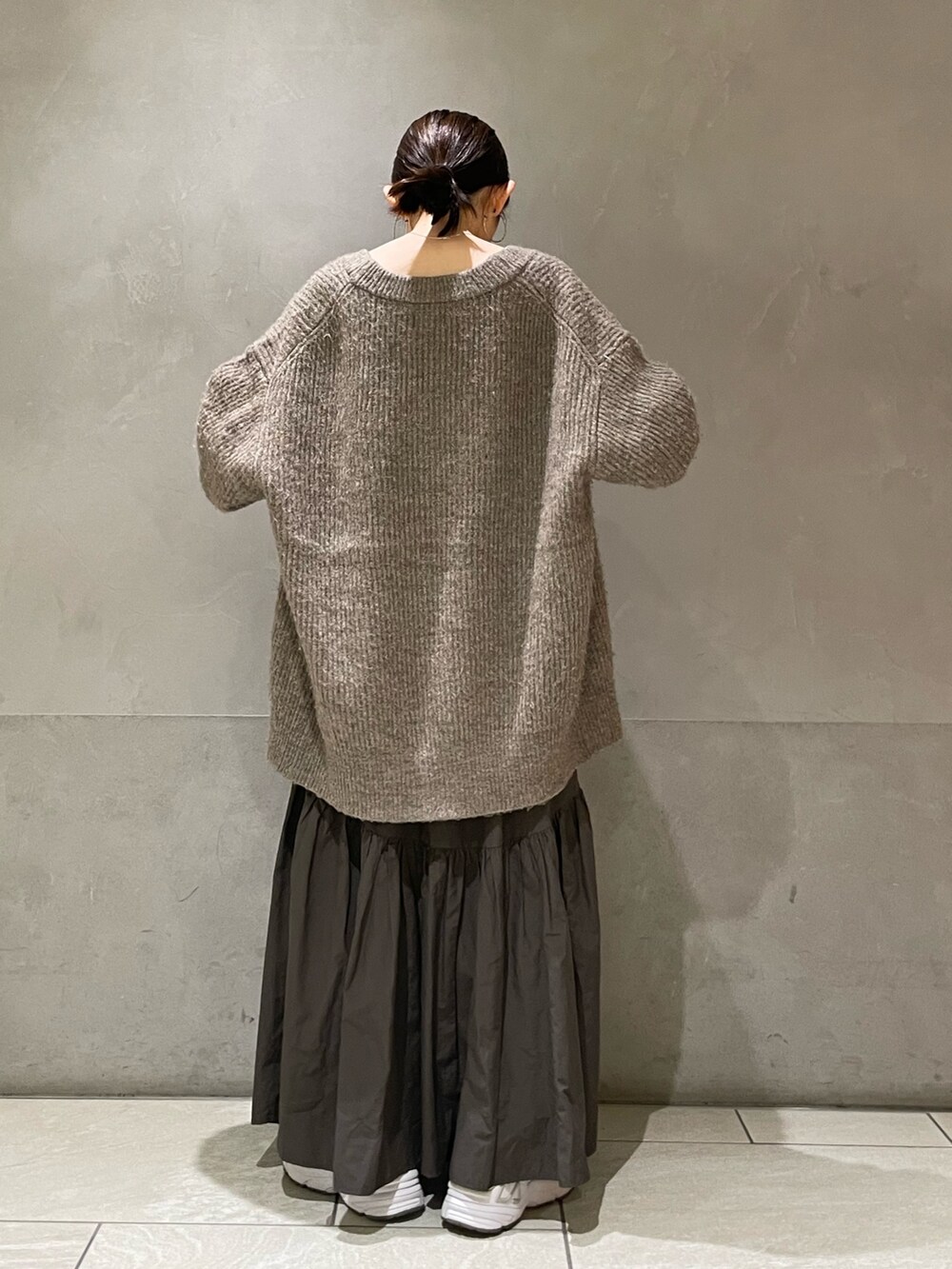 グレー系のカーディガン/ボレロ、グレー系のスカートを着用したレディースの秋コーディネートの4枚目の写真