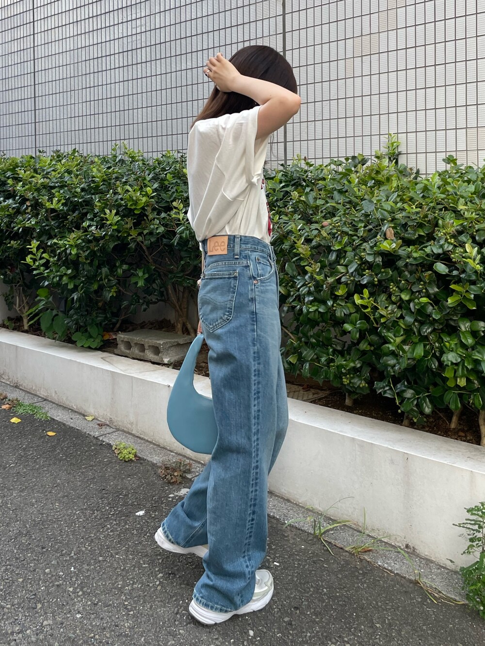 ホワイト系のTシャツ/カットソー、ブルー系のハンドバッグ、ブルー系のデニムパンツを着用したレディースの夏コーディネートの3枚目の写真