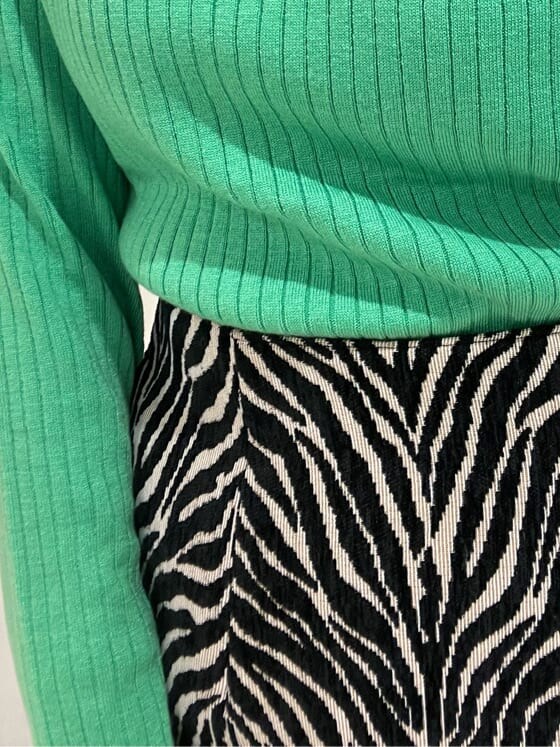 ホワイト系のハンドバッグ、グリーン系のニット/セーター、ブラック系のスカートを着用したレディースの秋コーディネートの7枚目の写真