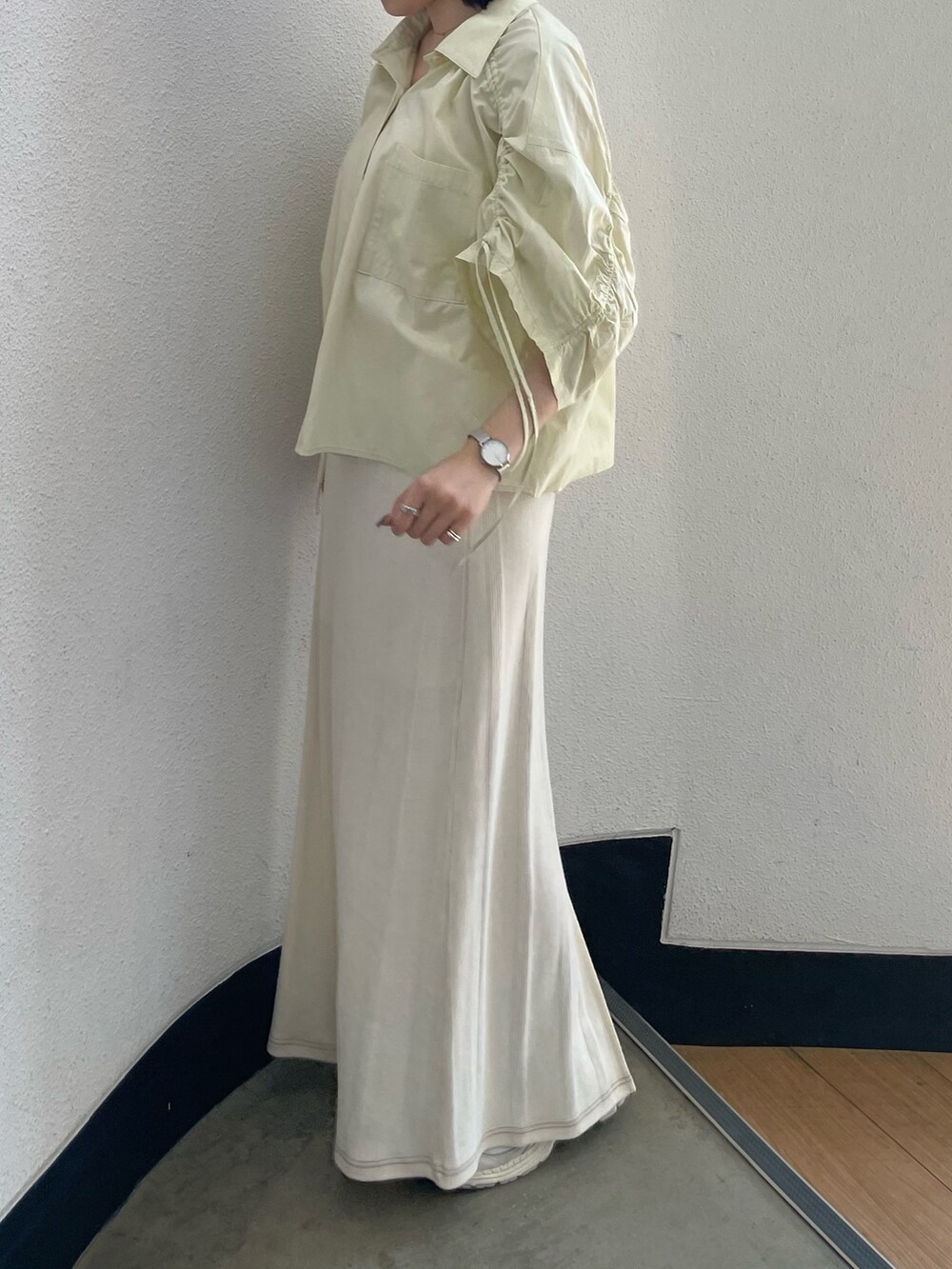 イエロー系のシャツ/ブラウス、ホワイト系のキャミソール、ホワイト系のスカートを着用したレディースの春コーディネートの4枚目の写真