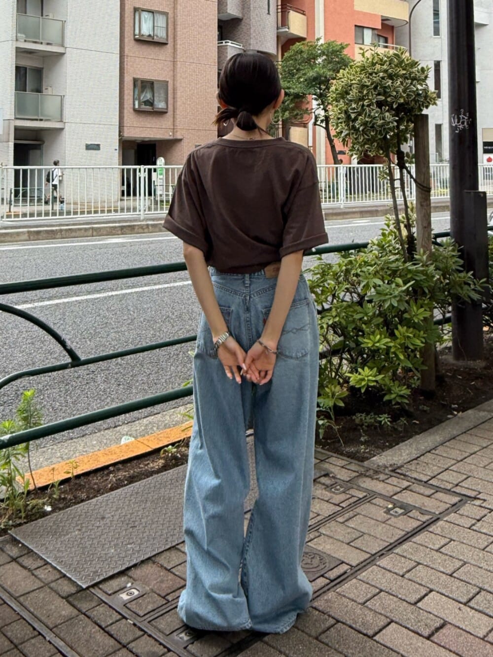 ブラック系のサンダル、ブルー系のデニムパンツ、ブラウン系のTシャツ/カットソーを着用したレディースの夏コーディネートの3枚目の写真