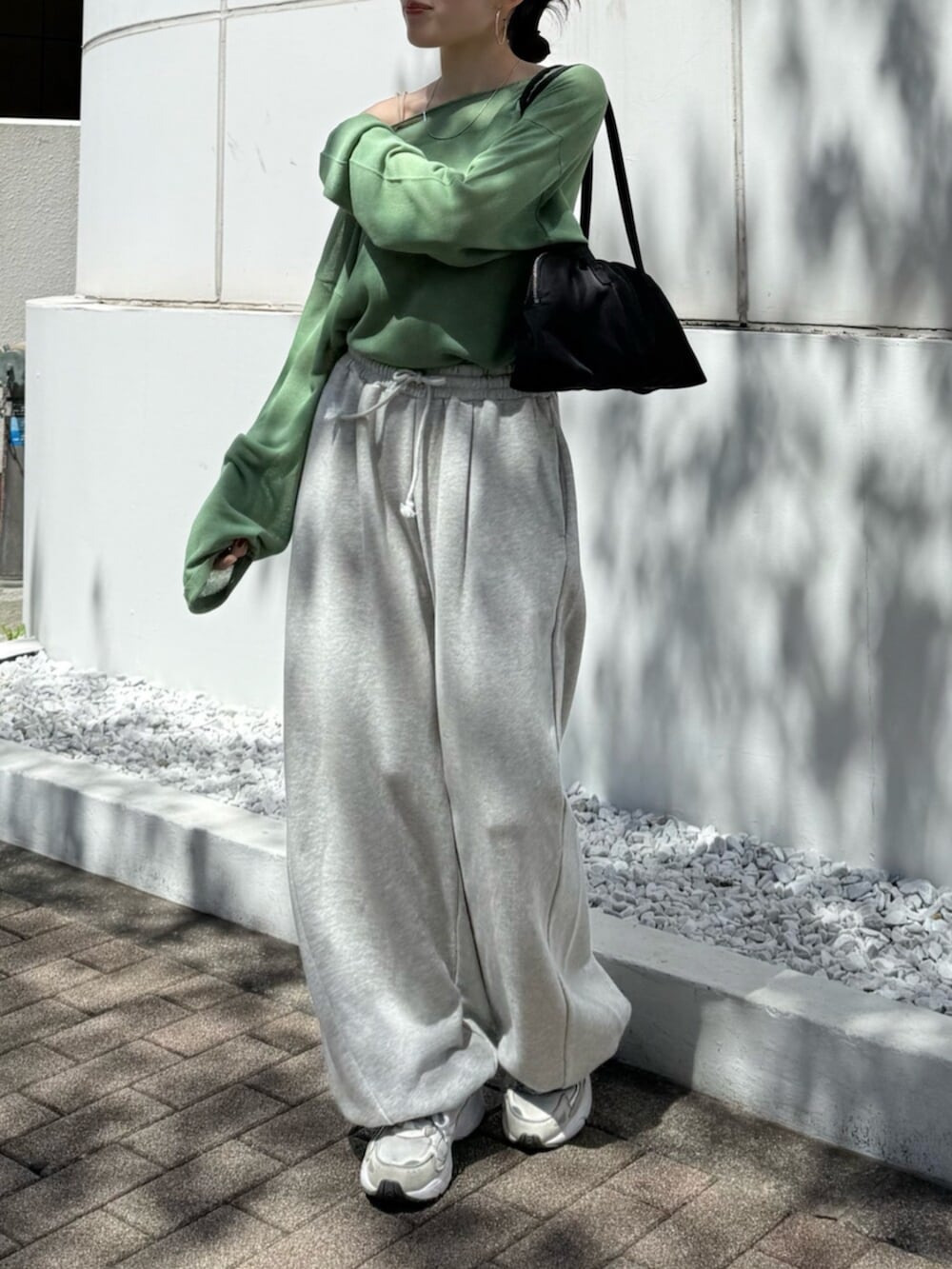 グレー系のスウェットパンツ、ブラック系のハンドバッグ、グリーン系のニット/セーターを着用したレディースの春コーディネートの4枚目の写真