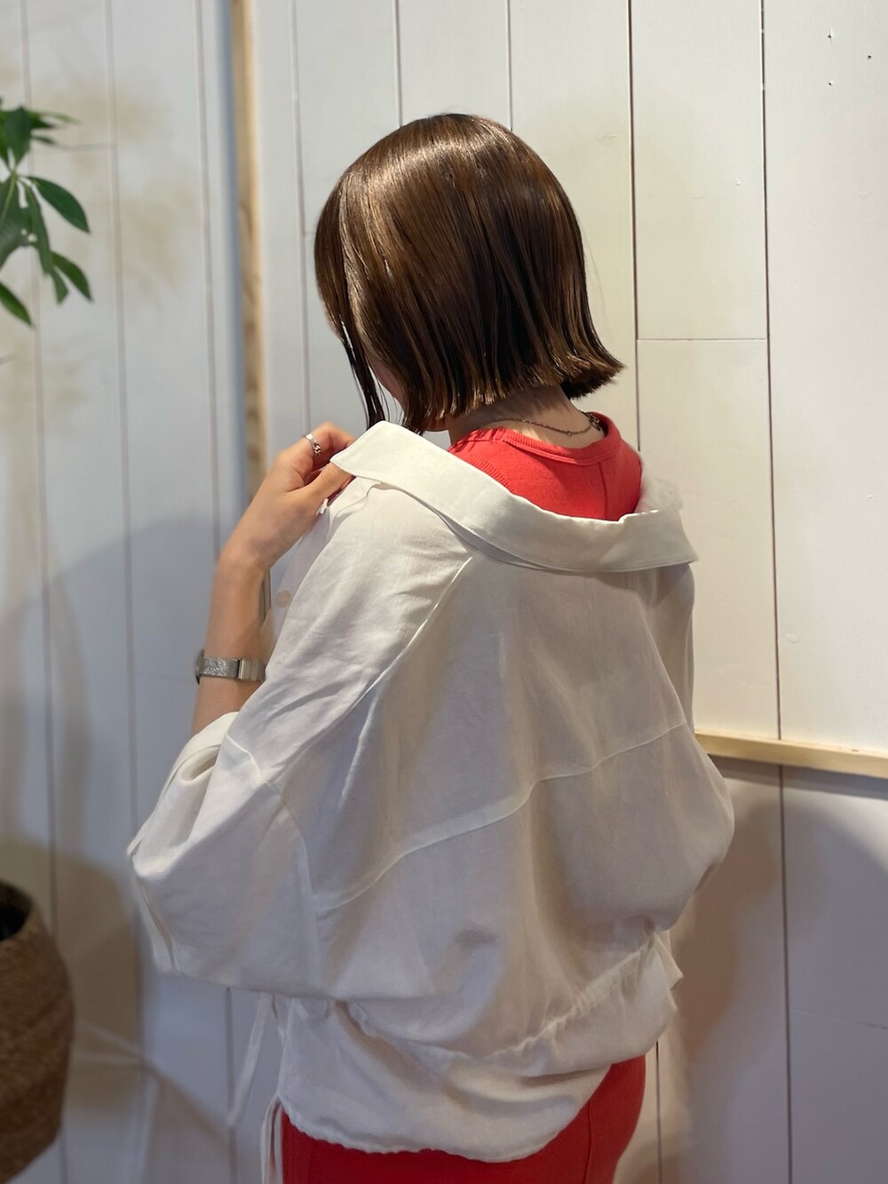 オレンジ系のワンピース、ホワイト系のシャツ/ブラウスを着用したレディースの春コーディネートの4枚目の写真