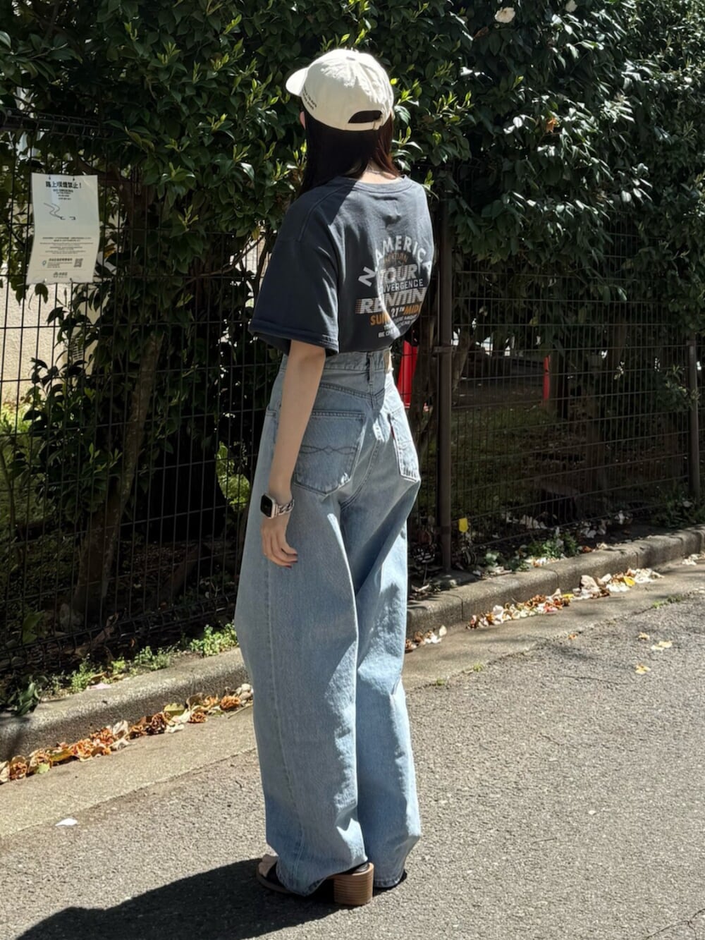 ブルー系のデニムパンツ、ブラック系のサンダル、グレー系のTシャツ/カットソーを着用したレディースの春コーディネートの5枚目の写真