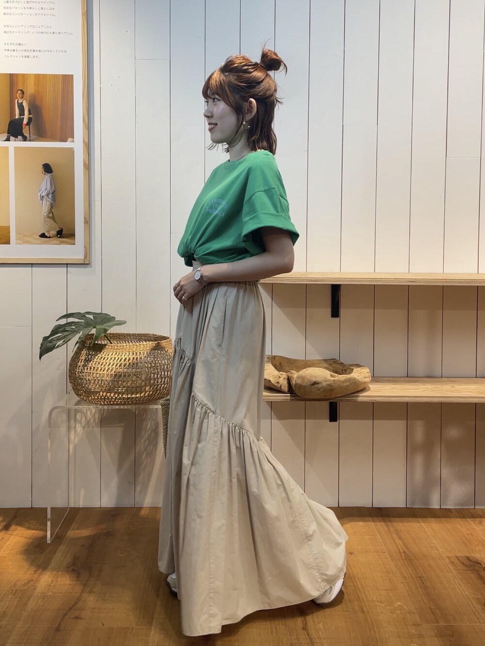 グリーン系のTシャツ/カットソー、ホワイト系のスカート、ベージュ系のかごバッグを着用したレディースの夏コーディネートの4枚目の写真