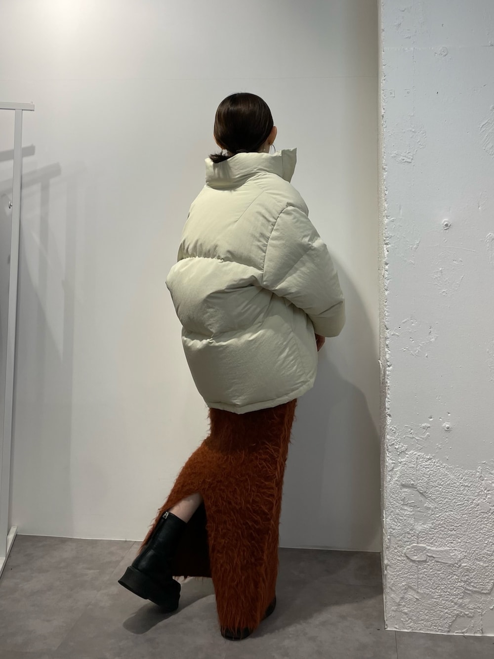 ブラック系のブーツ、ホワイト系のダウンジャケット/コート、オレンジ系のスカートを着用したレディースの秋コーディネートの4枚目の写真