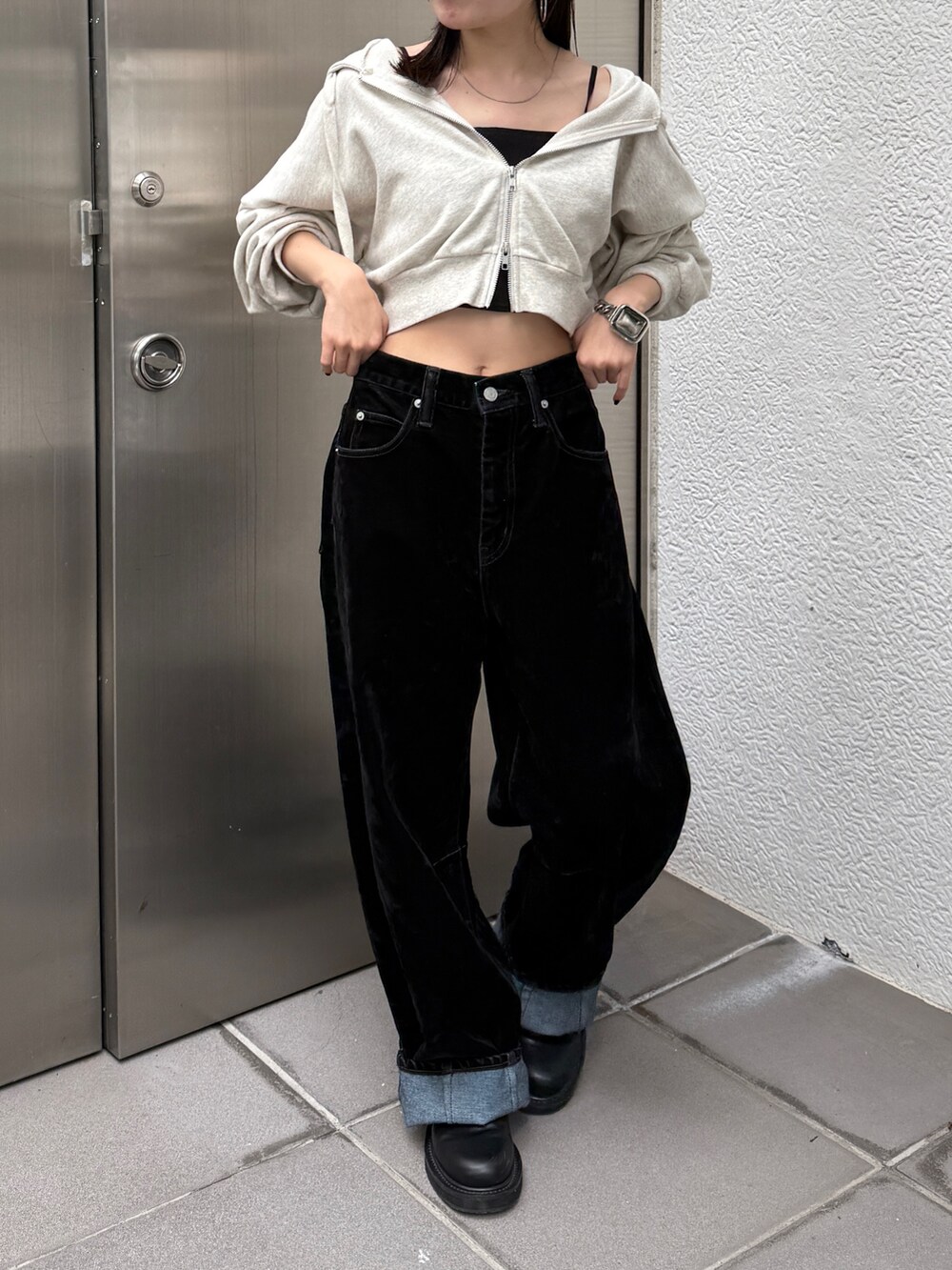 ホワイト系のパーカー、ブラック系のデニムパンツ、ベージュ系のキャップを着用したレディースの秋コーディネートの2枚目の写真