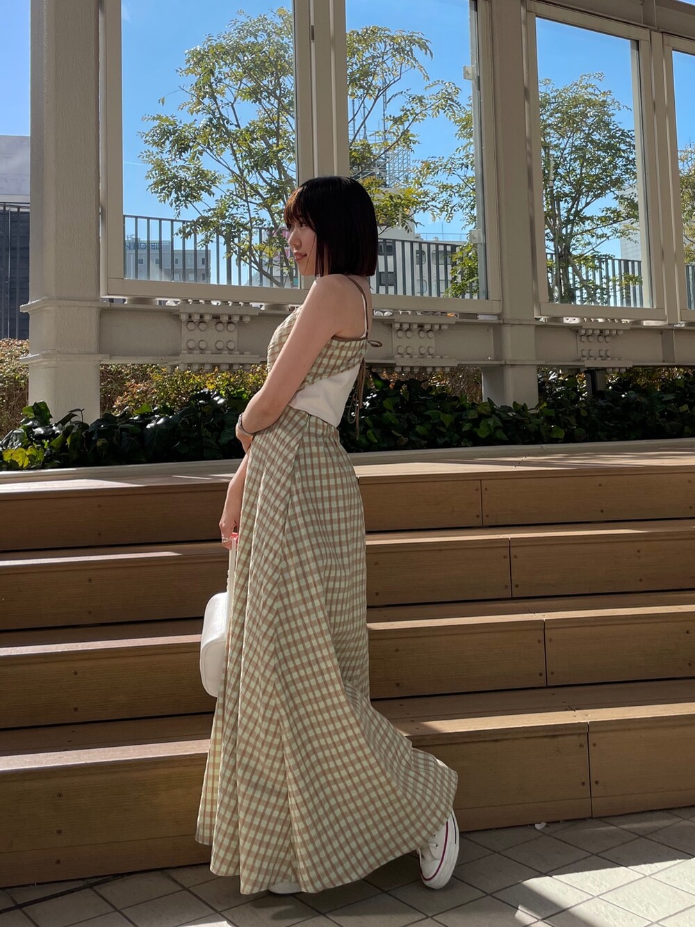 ホワイト系のハンドバッグ、グリーン系のワンピース、ブルー系のデニムジャケットを着用したレディースの冬コーディネートの5枚目の写真