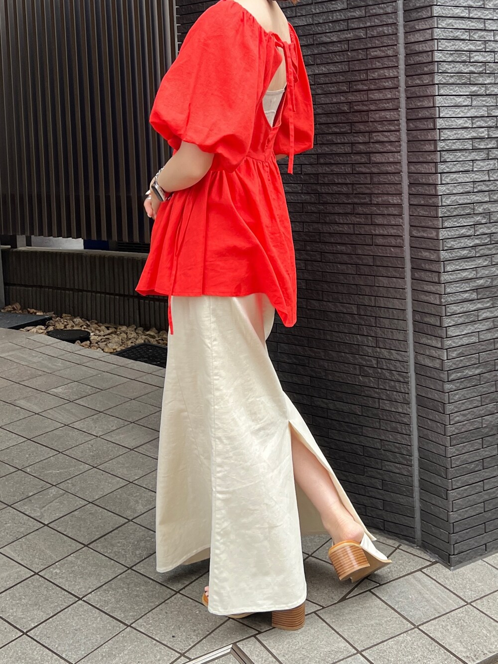 グレー系のキャミソール、ホワイト系のスカート、ホワイト系のサンダルを着用したレディースの春コーディネートの5枚目の写真