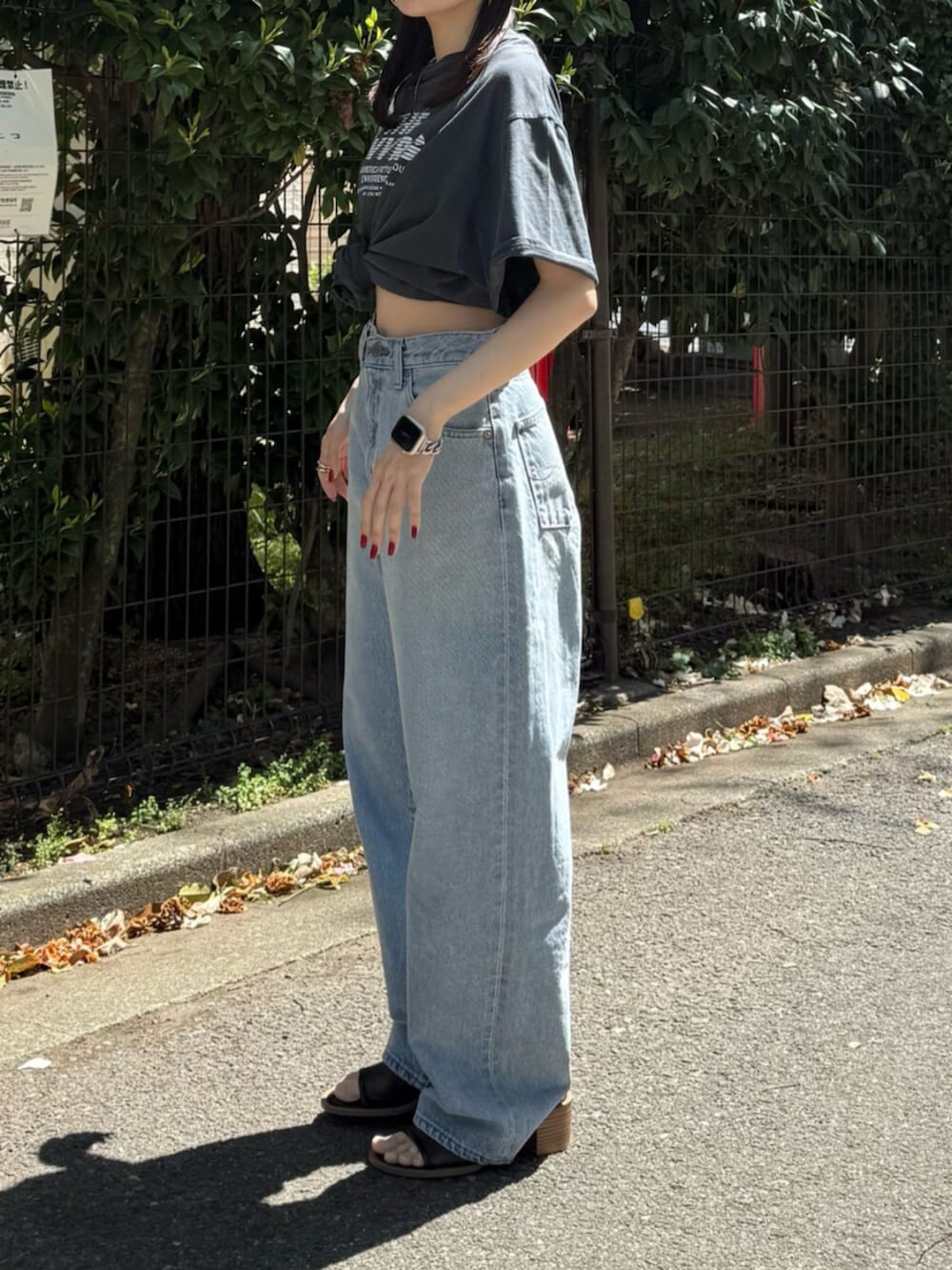 ブルー系のデニムパンツ、ブラック系のサンダル、グレー系のTシャツ/カットソーを着用したレディースの春コーディネートの7枚目の写真